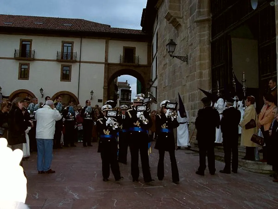 El grupo de metales de la agrupación toca en el interior de una iglesia, bajo un crucifijo.