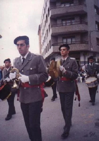 Dos músicos con uno de los primeros uniformes de la agrupación, tocando por la calle.
